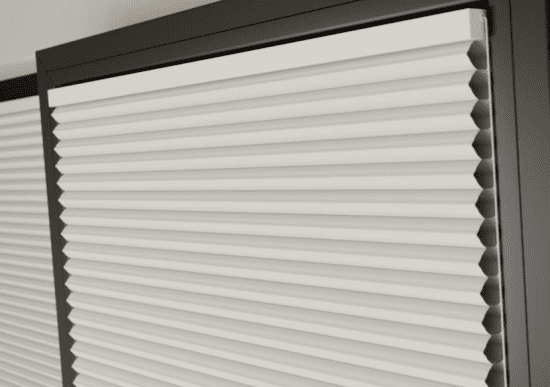 This image shows white clic honey comb blinds fitted onto a black window frame