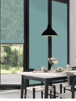 This image shows turquoise clic blinds fitted onto black framed patio doors next to a dining room table.