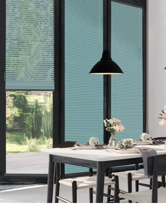 This image shows turquoise clic blinds fitted onto black framed patio doors next to a dining room table.