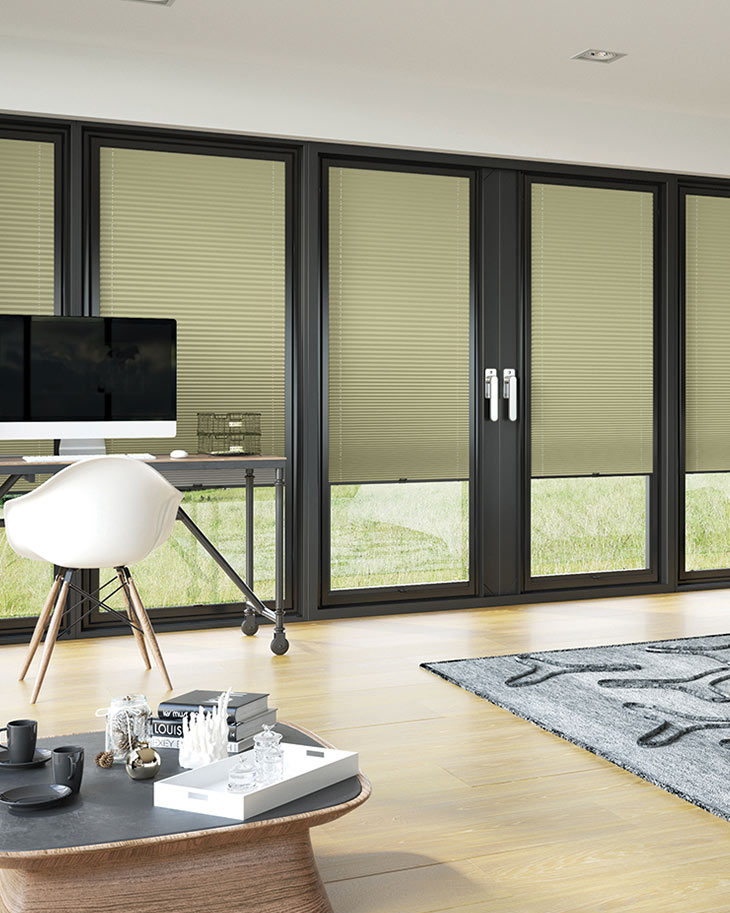 This image shows khaki green pleated bi-fold blinds fitted onto black framed glass doors